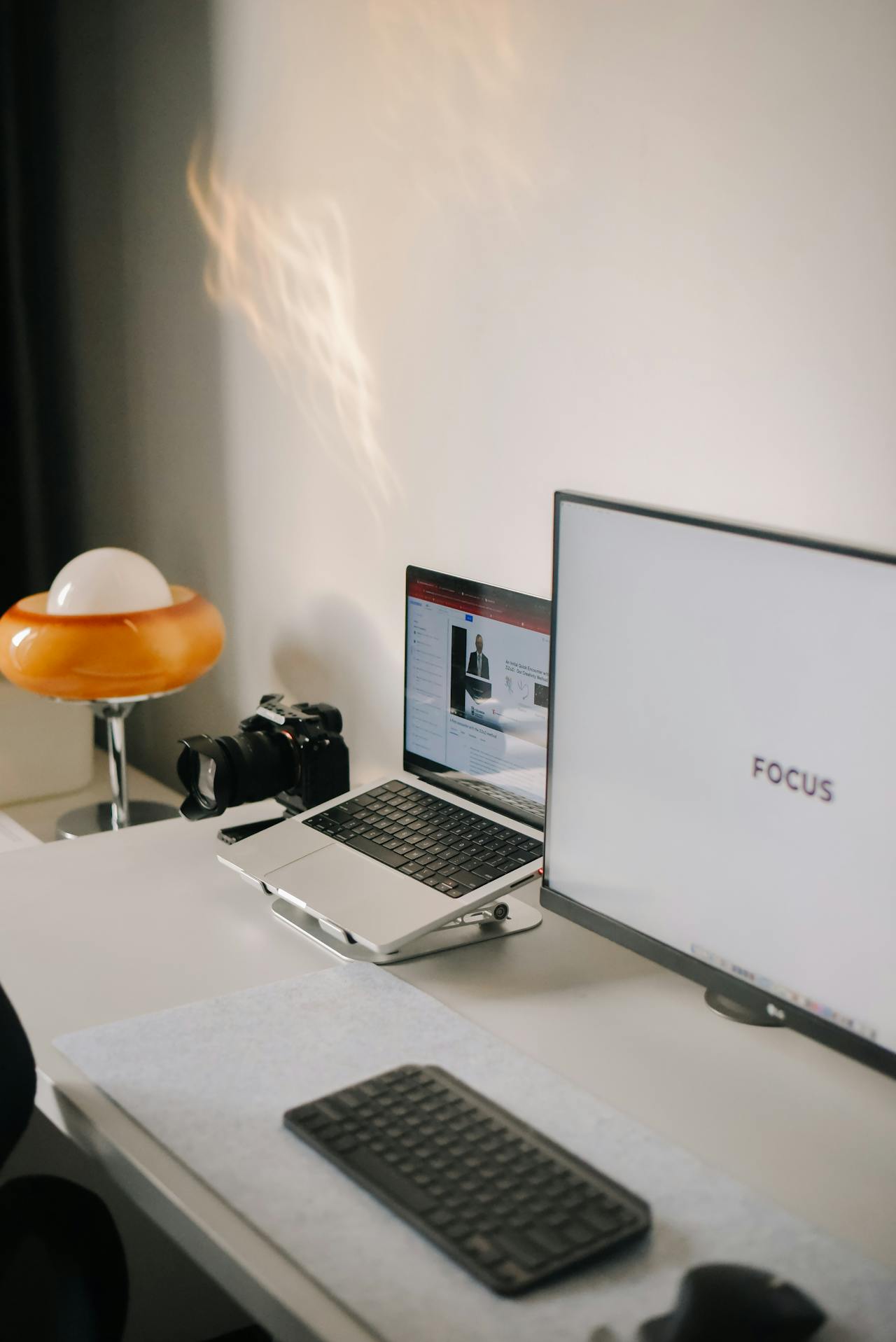 Laptop neben PC Bildschirm